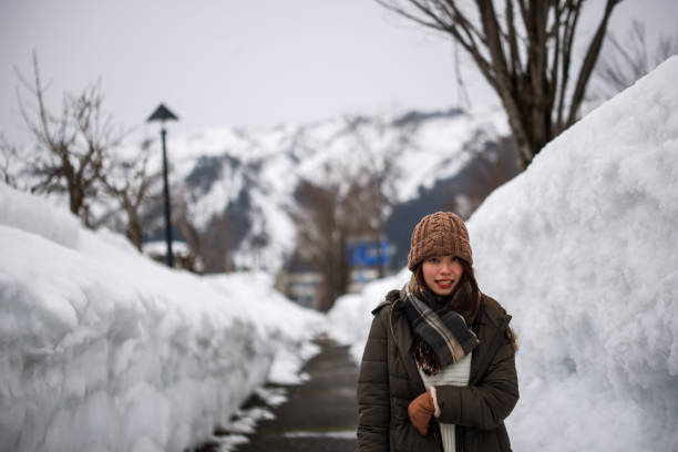 istock Beautiful young woman walking on piled snow 1306800394