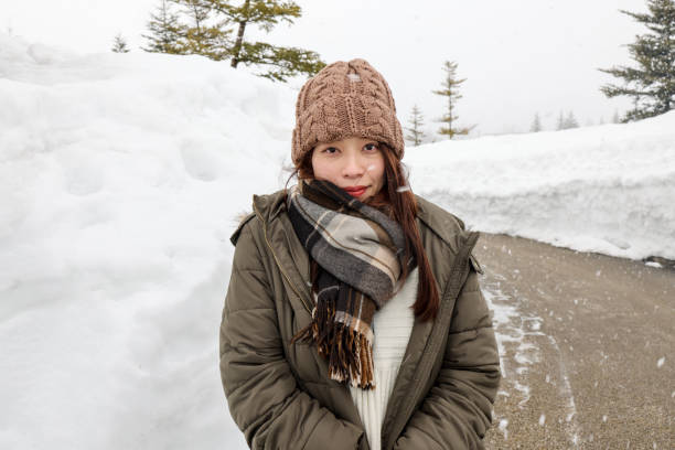 istock Beautiful young woman relaxing  at snow covered park 1306801285