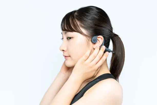 Photo of Young woman wearing a bone conduction headphones.