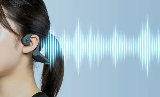 Photo of Young woman wearing a bone conduction headphones.