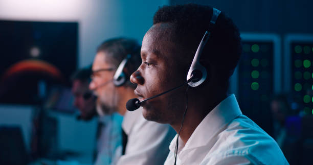 Black dispatcher talking while controlling flight Pan around view of African American man with headset speaking during work in flight control center real time stock pictures, royalty-free photos & images