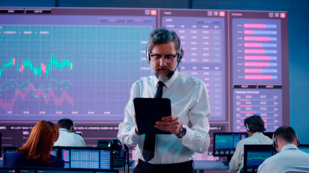 istock Mature leader amidst stock traders team 1306803558