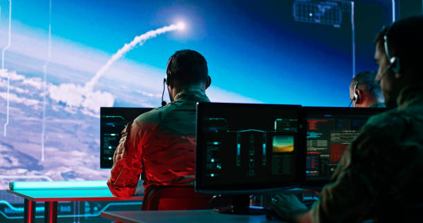 Male soldiers launching nuclear missiles in command center Zoom in view of military men using computers to watch online broadcast and launch nuclear missile during work in control center during world war nuclear weapon photos stock pictures, royalty-free photos & images