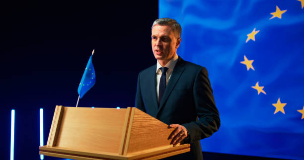 istock Energetic politician speaking with audience from podium 1306804727