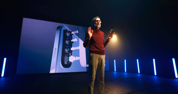 istock Mature man showing new smartphone on stage 1306804872
