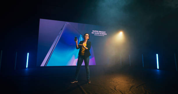 istock Energetic woman starting smartphone presentation on stage 1306804884
