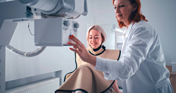 istock Female patient speaking with doctor during X ray scanning preparation 1306804929