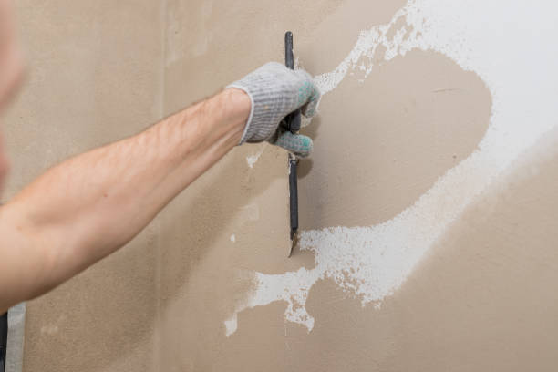 istock Process putty concrete wall with a metal spatula.process of applying a layer of putty. Renovation of apartments. Repair the walls. Free space for advertising, text.Repair of the living quarters. 1306810079