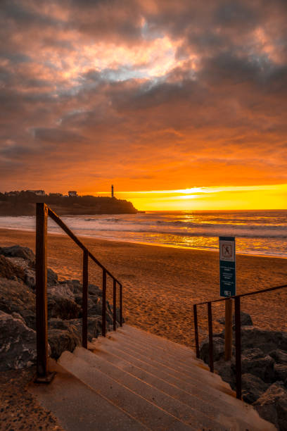 coucher du soleil sur la plage de biarritz appelé plage de la petite maison de l’amour, france. vu de l’escalier. - northumberland england bamburgh lighthouse beach photos et images de collection