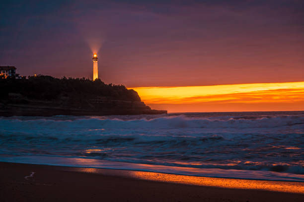 phare de biarritz à la plage de la petite maison de l’amour à biarrtiz dans un beau coucher de soleil. france - northumberland england bamburgh lighthouse beach photos et images de collection