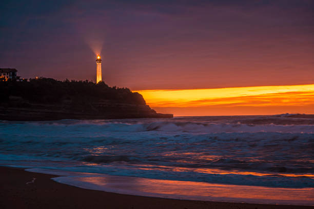 phare de biarritz à la plage de la petite maison de l’amour à biarrtiz dans un beau coucher de soleil. france - northumberland england bamburgh lighthouse beach photos et images de collection