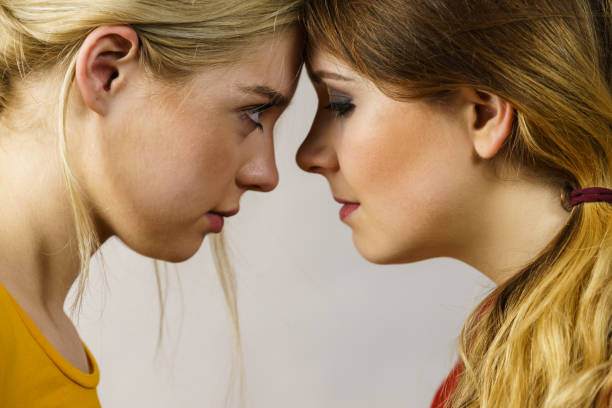 istock Two girls looking serious at each other. 1306816520
