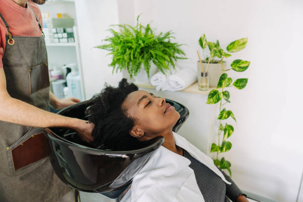 Washing hair in a hair salon Photo of a hairdresser, washing hair to a customer with an Afro hair black woman washing hair stock pictures, royalty-free photos & images
