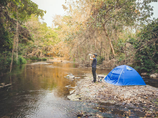 istock summer camping tent near the stream. 1306817049