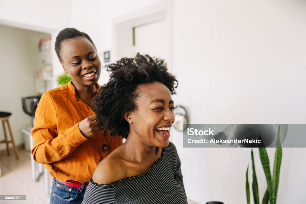 In a hair salon Photo of a young African American hairdresser, blow drying hair of her customer in a hair salon. Hair Salon Stock Photo
