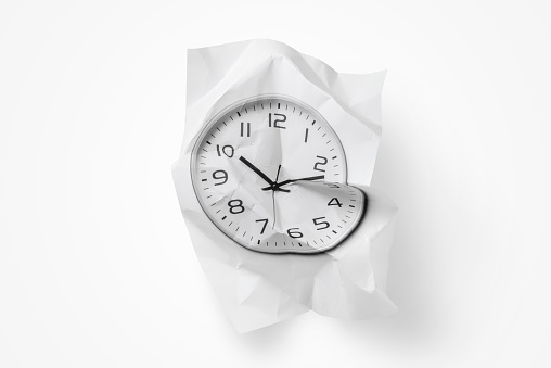 Crumpled photograph of a watch isolated on white background.