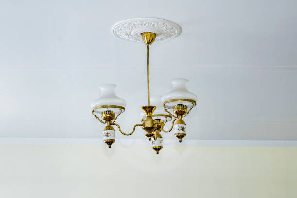 Classical retro chandelier white and golden colored hanging on ceiling. Concept vintage lamp and luster.