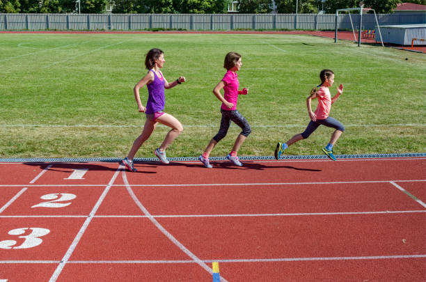 forme physique de famille, mère et gosses exécutant sur la piste de stade, exercice avec des enfants et concept sain de mode de vie de sport - track and field 30s adult athlete photos et images de collection