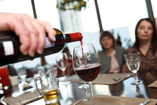 istock Person pouring red wine 1306821327