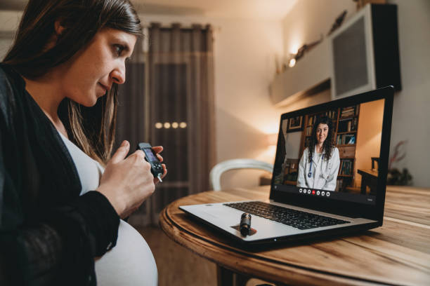 una joven embarazada está teniendo una videollamada con su médico mientras está probando su curva de azúcar en la sangre - diabetes human pregnancy women blood sugar test fotografías e imágenes de stock