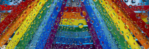 istock Rainbow. Multicolored raindrops are located against strips of rainbow colored paper. Abstract fantasy. 1306827039
