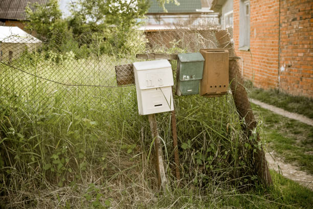 istock Vintage rustic mailboxes of different colors pinned on a fence. floating focus 1306833127