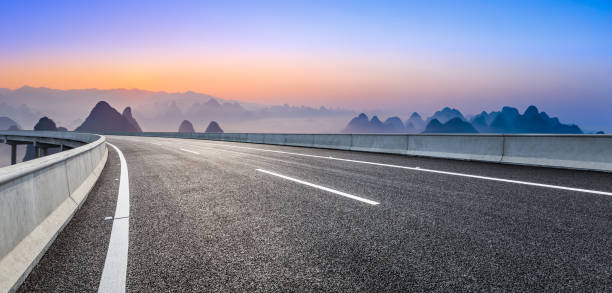 istock Empty road and beautiful mountains at sunrise in Guilin. 1306837391