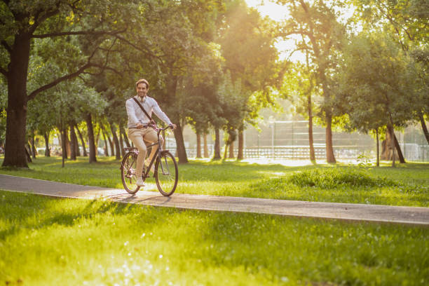 istock Young man rides a bicycle to work in the morning 1306838469