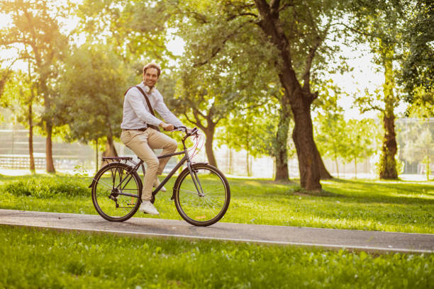 istock Young man rides a bicycle to work in the morning 1306838514