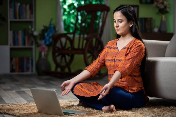 portrait of young women using laptop doing yoga at home: stock photo young women, adult, yoga, spirituality, online classes, meditation, online yoga stock pictures, royalty-free photos & images