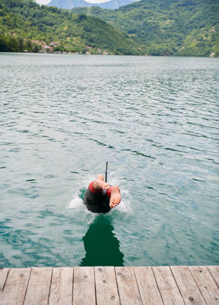 istock triathlon athlete jumping in water and starting with training 1306840927