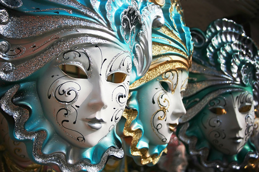 Venice, Italy - March 01, 2022: Woman dressed in traditional costume stand in front of the Bridge of Sighs, part of the Venice Mask Carnival, Veneto, Italy