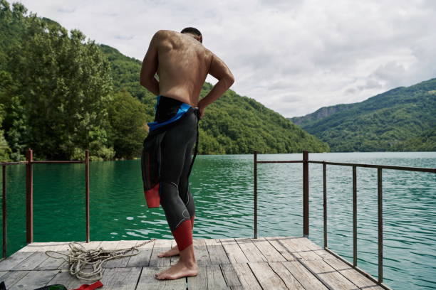 istock triathlon athlete getting ready for swimming training on lake 1306842473