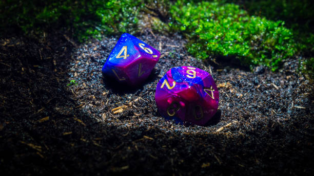 istock Two blue and purple d10 laying in wet soil 1306846018