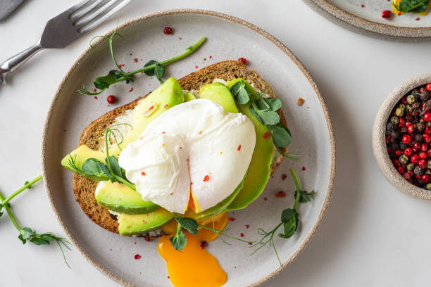 istock Sandwich with poached egg, avocado, sprouts and cheese for healthy breakfast on white background. top view 1306846692