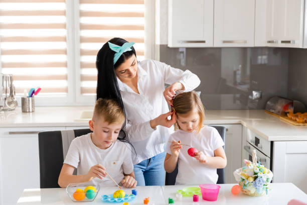 istock Happy Easter! Children with mother paint and draw Easter eggs. 1306846922