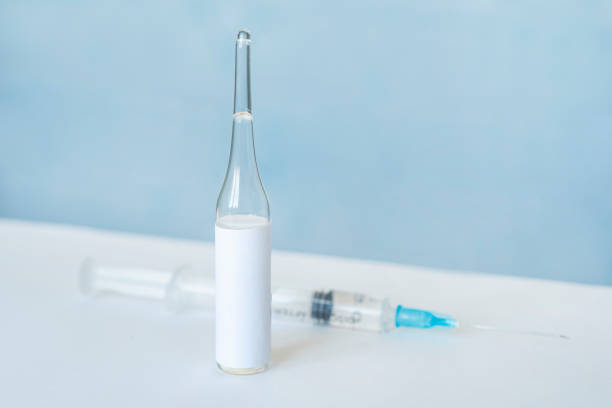 istock close-up of small ampoule with empty label and syringe defocused blurred on background. macro shot with lot of copy space. vaccine epidemic medical research concept 1306848156