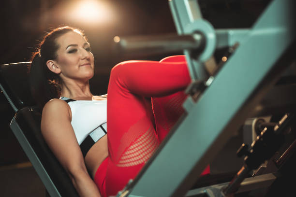 istock Young woman practicing legs on the machine in a gym 1306851023