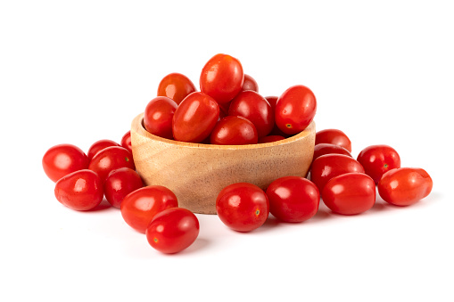 Cherry tomatoes in a wooden bowl isolated on white background