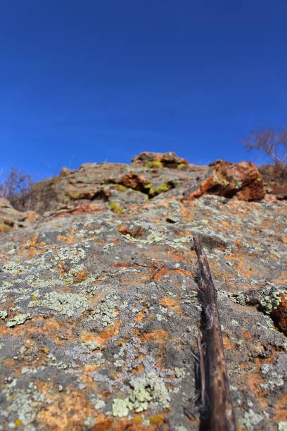 istock Lichen Covered Rock on Top of Cliff against Blue Sky 1306851855