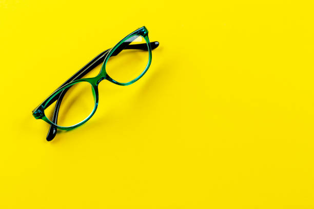 istock Stylish glasses for correcting vision on a yellow background. Fashionable accessory. Space for text. 1306859885