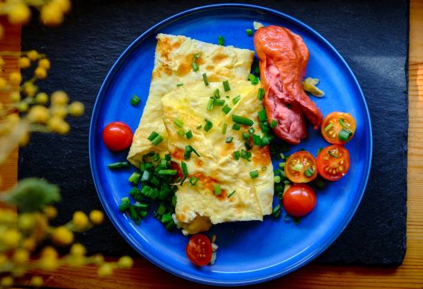 istock Omelette with tomatoes, green onion on blue plate 1306859969