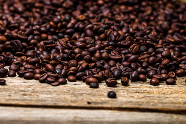 istock Roasted coffee beans isolated on wooden table. 1306860704
