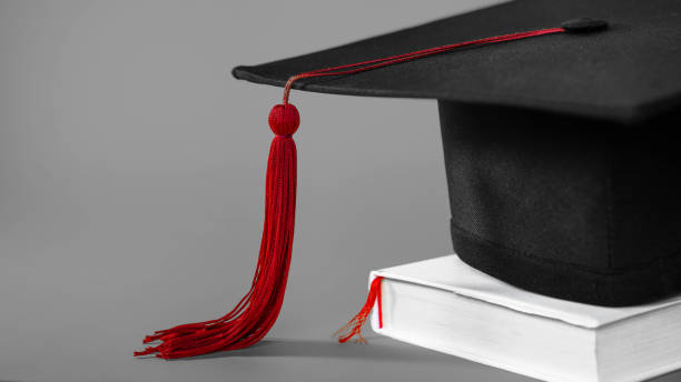 istock A mortarboard on isolated gray background with empty copy space to the left. Stock photo 1306861973