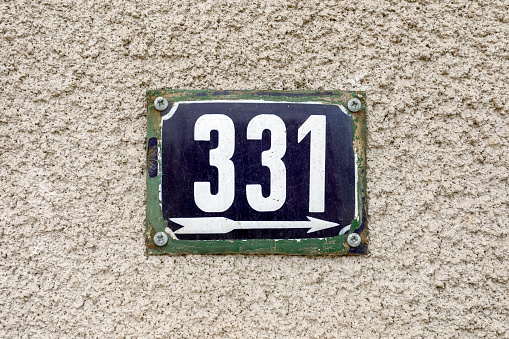 Number 331 number of houses apartments streets. White number of blue metal plate house number three hundred and thirty-one (331) on a rough wall