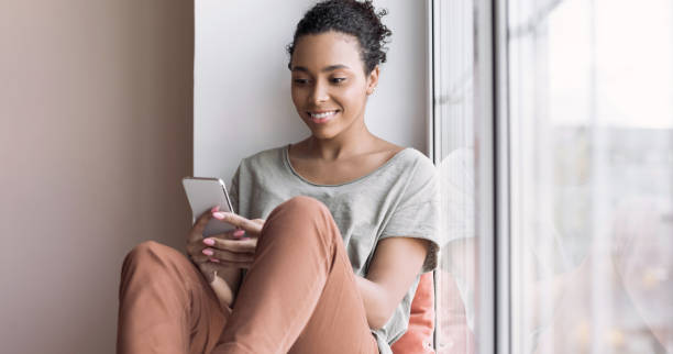 istock Woman using smartphone at home. Girl texting on mobile phone 1306863191