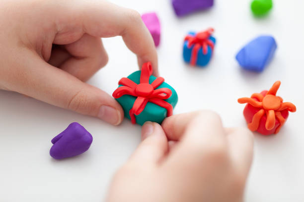 A young boy making polymer clay gift boxes A young boy making polymer clay gift boxes. Shallow depth of field. Close up. polymer clay stock pictures, royalty-free photos & images