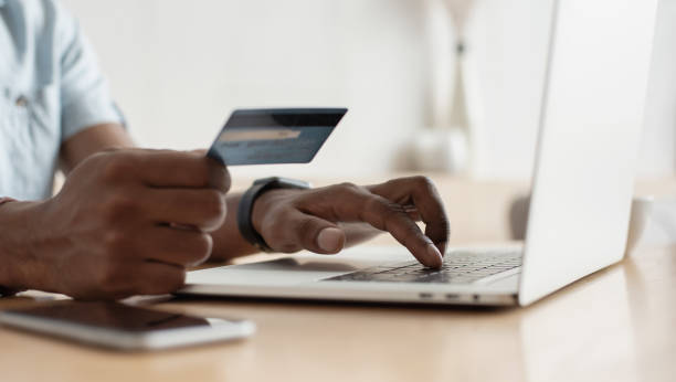 Man shopping online with laptop and credit card Young men using laptop computer and holding credit card. Online shopping, internet payment, banking concept spending money stock pictures, royalty-free photos & images