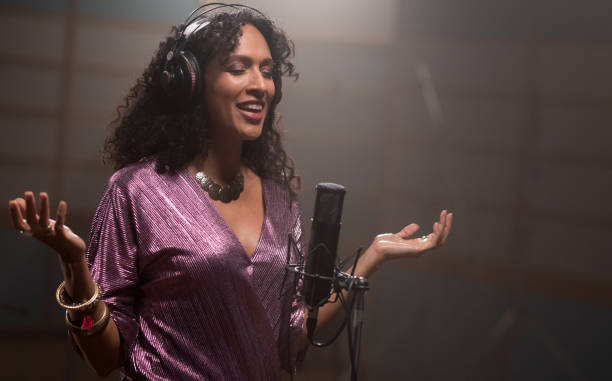 Female Singer Singing Into Microphone In Recording Studio