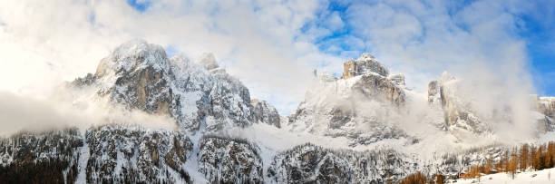 istock Dolomite Mountains covered with clouds in winter. On sunrise. Panoramic view from Colfosco village. 1306869261